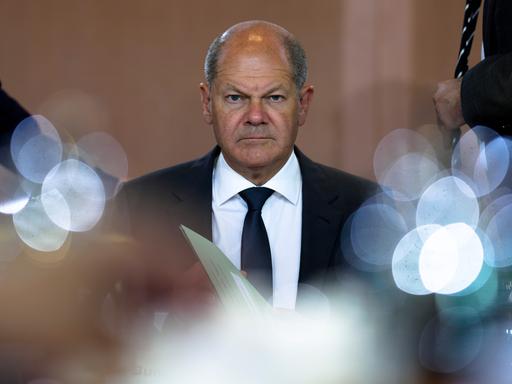 Bundeskanzler Olaf Scholz guckt ernst in die Kamera